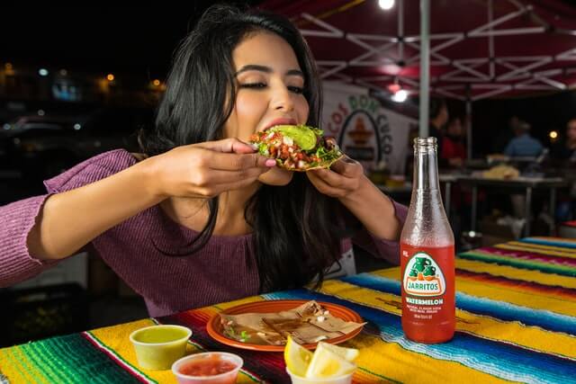 11Woman enjoying a tostada in a Mexican restaurant