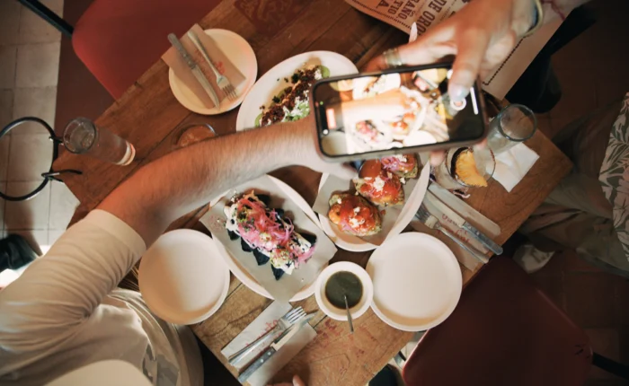 Overhead view of guests taking photos of colorful Yucatecan tapas on a cantina table