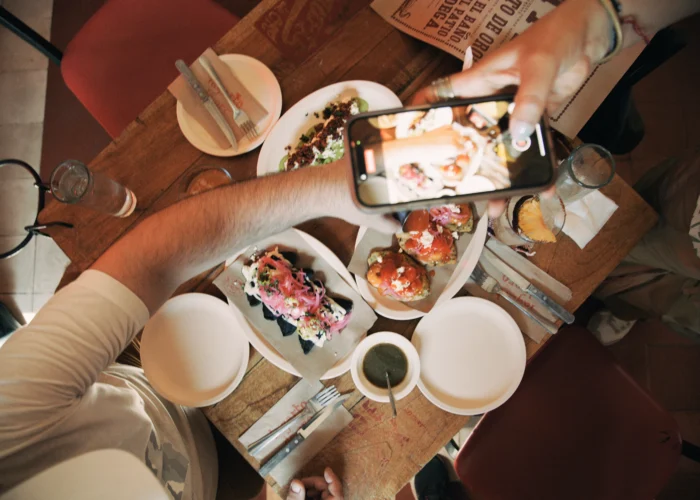 Overhead view of guests taking photos of colorful Yucatecan tapas on a cantina table